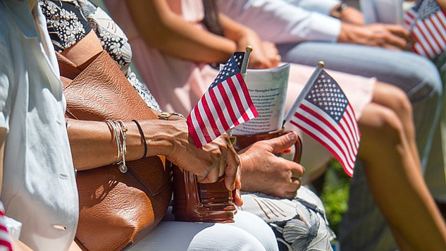 people sitting in a stadium holding small flags in their hands