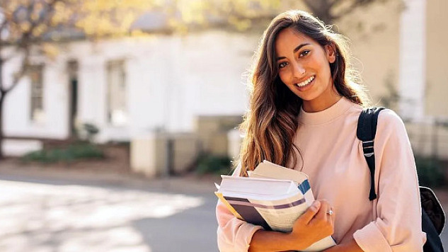 A college student reviewing books and career plans, representing the importance of choosing the right major.