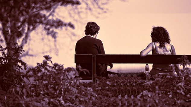 two people sitting far apart on a bench