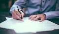 picture of a man writing on sheets of paper