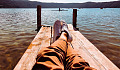 a man laying back on a dock, relaxing