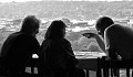 three people sitting at a table in deep conversation