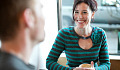 a smiling woman having a cup of coffee with someone