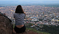 a woman sitting overlooking a city