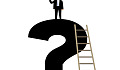 man using a telescope standing on top of a question mark