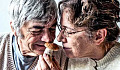 An older couple smells a mushroom together