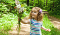 young girl holding out a bunch of wildflowers