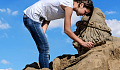 a woman creating a sand-rock sculpture