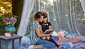 mother and daughter sitting together on a bed, reading a book