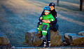 a child sitting on his mother's lap - both are smiling