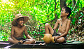 two boys sitting by the water and laughing joyfully