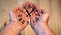 open hands with the numbers and needles of a clock superimposed on the hands