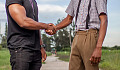 two men from different backgrounds shaking hands