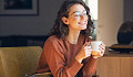 a cheerful young woman holding a cup