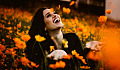 a woman laughing in a field of bright orange flowers